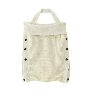 Detailed view of off-white halter knit top with dark side button accents on a white background