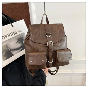 Gros plan du sac à dos vintage en similicuir marron avec des boucles argentées