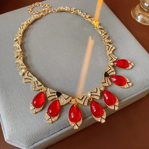 Top-down shot of a vintage gold necklace with red teardrop gem and bow-shaped diamonds