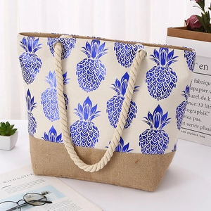 Detail of canvas tote bag with pineapple print, burlap base, and white rope handles