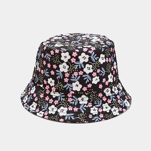 Detail of floral bucket hat showing pink flowers and reinforced stitching on the black brim