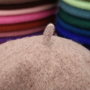 Elegant wool beret in oatmeal beige color with classic top stem and soft texture
