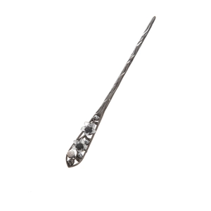 Close-up of hair stick with white flower, grey pearls and intricate carved textures