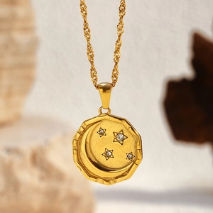 Macro detail of 18k gold plated moon and star medallion pendant with zircon on twisted chain