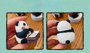 Detailed view of handmade panda resin figurine with realistic fur texture and writing pose
