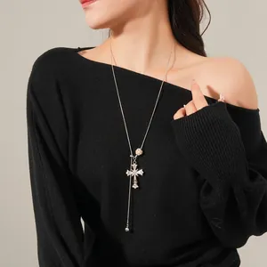 Tiger eye stone cross pendant necklace with rhinestones on model with black sweater
