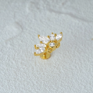 Macro view of gold fan-shaped cartilage stud with clear marquise-cut zircon stones