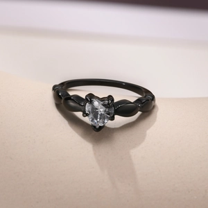 Macro detail of black heart-shaped ring with a clear zircon stone in a 4-prong setting