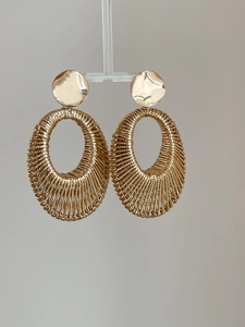 Detailed close-up of golden woven texture oval drop earrings with polished metal stud