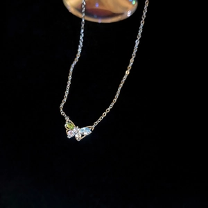Elegant gold butterfly necklace with colorful zircon gemstones on a dark background