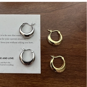 Close-up of minimalist S925 sterling silver U-shaped hoop earrings in gold and silver finish
