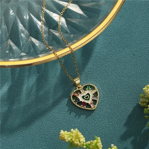 Golden heart necklace with colorful zircon stones and enamel pendant on textured background