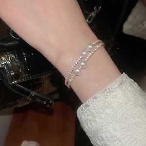 Vue détaillée du bracelet double couche doré avec quatre perles et pavé de cristaux