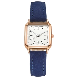 Detail of square rose gold quartz watch with blue leather strap and Arabic numerals