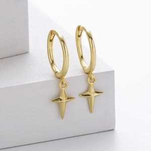 Detail of gold S925 sterling silver hoop earrings with four-pointed star charms on white stand