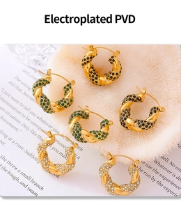Macro detail of PVD plated twisted hoop earrings with green, black, and white zircons