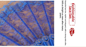 Detailed macro view of dark blue lace floral pattern and gold carved fan bone