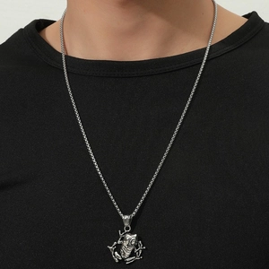 Detailed close-up of a punk style silver crocodile pendant on a sleek box chain for men