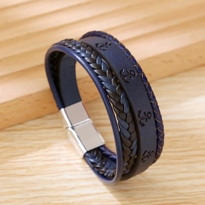 Detailed shot of dark blue braided leather bracelet with anchor embossing and silver clasp
