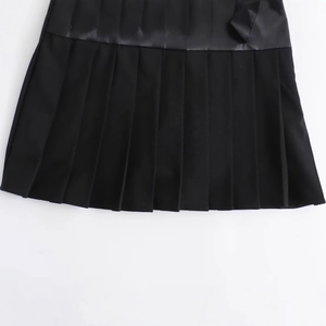 Fashionable black faux leather pleated skort featuring a high-gloss finish and clean folds