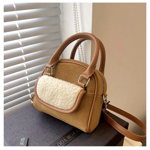 Detail of plush lamb wool and brown suede handbag with elegant circular silver metal handles