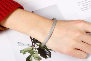 Silver matte titanium steel open cuff bracelet worn on wrist with minimalist background