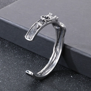 Dettaglio del rilievo del drago vintage e della texture sul bracciale aperto in acciaio