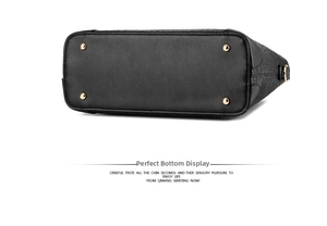 Detail view of the black embossed leather bag base with four golden metal feet