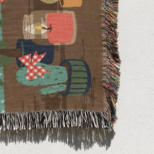 Detail of woven tapestry with colorful fringes and bohemian cartoon plant pattern