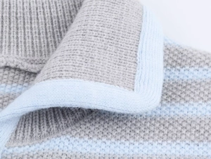 Detailed macro view of the soft grey and blue striped knit fabric with polo collar detail