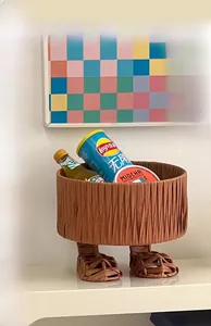 Creative foot-shaped woven storage basket holding snacks and drinks on a table
