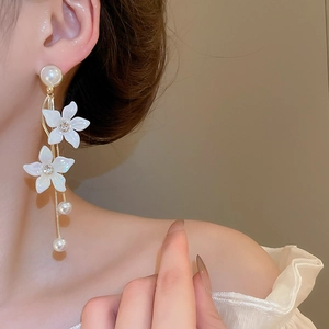 Close-up of elegant flower tassel earrings with pearls and silver needle on model