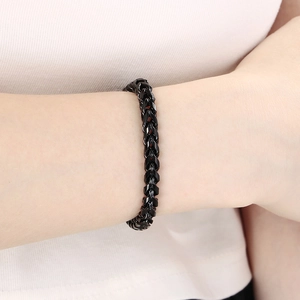 Gros plan d'un bracelet gourmette noir en acier inoxydable avec fermoir en H sur le poignet