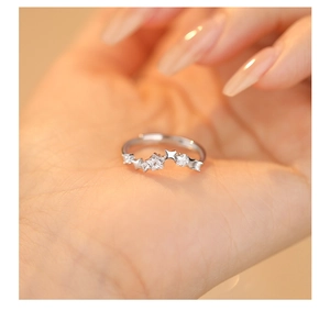 Macro shot of a sparkling silver star ring with brilliant zircon crystals on a hand