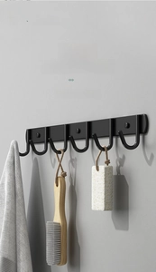 Detail of matte black stainless steel 6-hook rack with towels in a modern bathroom
