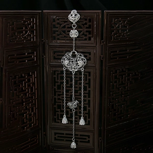 Detailed view of vintage silver tassel brooch with Chinese longevity lock and fortune motif