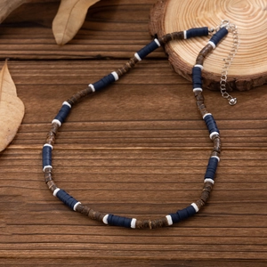 Men's bohemian coconut husk necklace with blue and brown polymer beads on wood