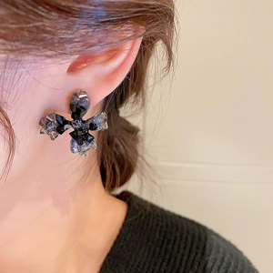 Boucles d'oreilles croix en cristal noir sur un mannequin en gros plan latéral
