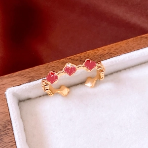 Détail d'une bague plaquée or 18 carats avec motifs cœurs rouges et zircons dans un écrin
