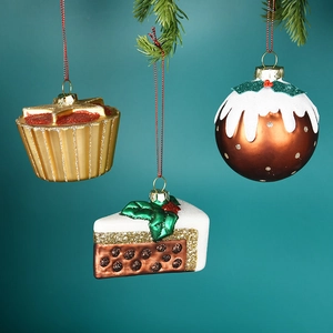 Sparkling dessert-shaped Christmas tree ornaments with glitter and red ribbons on pine branch