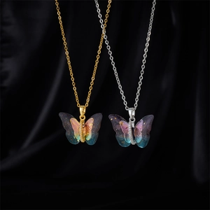 Sparkly butterfly pendant necklace with gradient colors and gold flakes on silk background