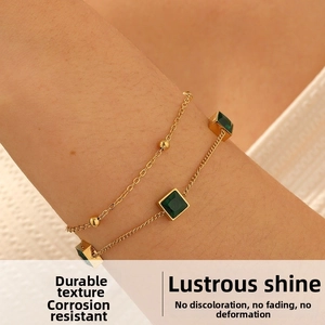 Detail of double-layer gold plated stainless steel bracelet with green square gemstone