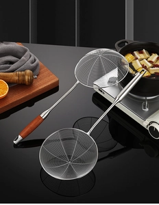 Macro view of stainless steel spider strainer with heat-resistant wooden handle