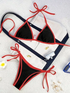 Flat lay of black and red color-block bikini with side-tie bottoms and beach accessories
