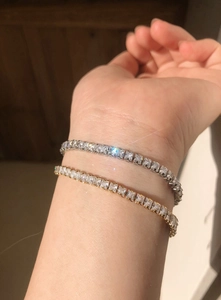 Macro shot of silver and gold tennis bracelets with square-cut sparkling cubic zirconia