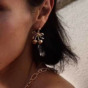 18k gold plated stainless steel bow cherry drop earrings shown on a model