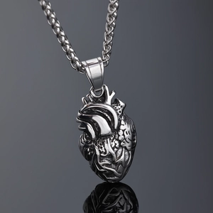Pendentif cœur anatomique argenté poli avec chaîne épi sur une surface réfléchissante