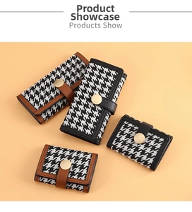 Flat lay of houndstooth wallets in various sizes with leather trim and gold metal buckles