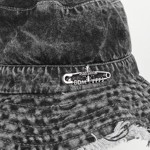 Denim bucket hat with checkered pattern, frayed edges and silver pin accents