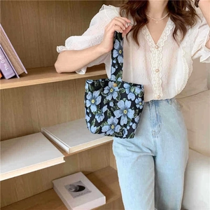 Close-up of floral jacquard canvas tote bag with metal snap button and strap detail